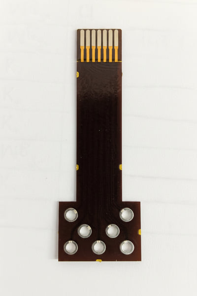 A small electronic flex cable connector with a dark brown body, gold-plated metal contacts, and circular pads, shown on a white background. screen print electrode for ions